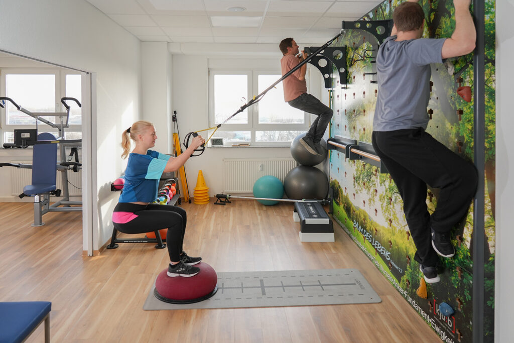 Menschen trainieren an der Multifunktion CubeWand, Ambulantes Zentrum Heinke